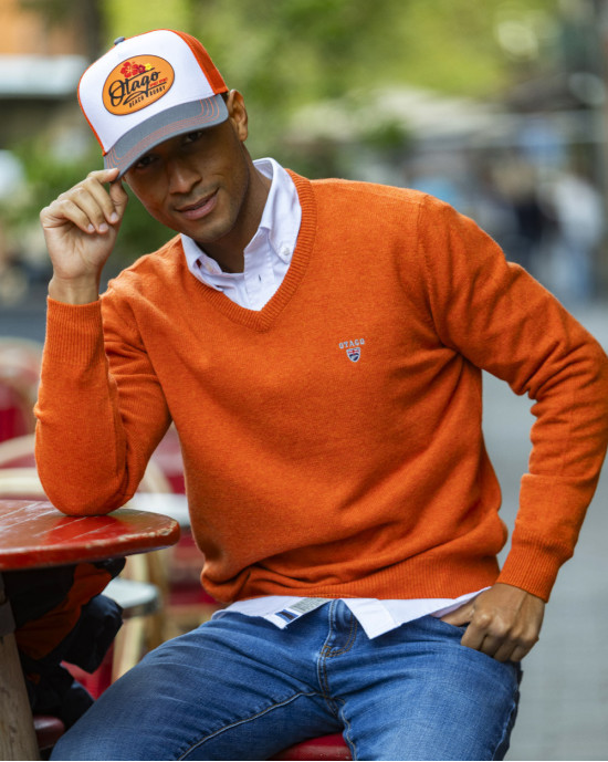 le modèle porte un Pull col V orange Buenos Aires Otago pour homme